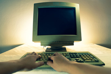 A man using an old personal computer and monitor . Ancient concept