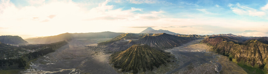 View from above, stunning panoramic view of the Mount Batok, Mount Bromo and the Mount Semeru in the distance illuminated at sunrise. Mount Bromo is an active volcano in East Java, Indonesia.