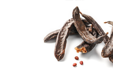 Carob carob fruit and seeds on white background. Isolate. Organic carob beans, a healthy alternative to cocoa.