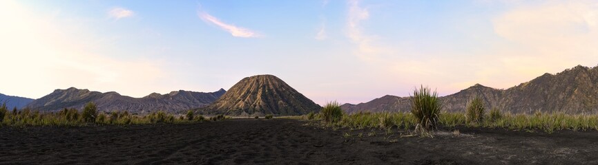 Stunning panoramic view of the Mount Batok and the Mount Bromo illuminated during a beautiful sunrise. Mount Bromo is an active volcano in East Java, Indonesia. © Travel Wild