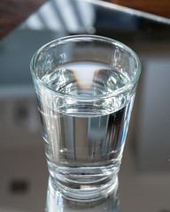 Nalewanie oczyszczonej świeżej wody do picia z butelki na stole w salonie