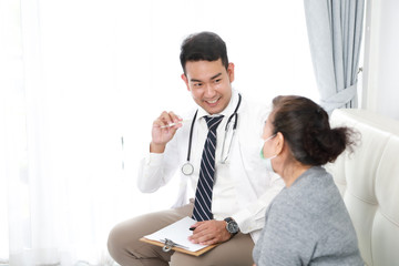 Asian young Doctor talking with Senior woman in hospital