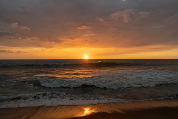 Fototapeta na wymiar Panoramic view of sunset in ocean. Nothing but sky, clouds, beach and water. Beautiful serene scene