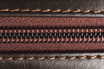 zipper of brown leather bag, close-up view