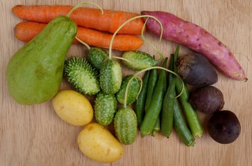 Vegetables and starches on white background. Carrots, okras, chayote, Indian gherkin, sweet potato and beet. Healthy food concept.
