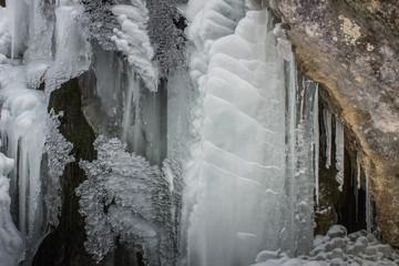 viele eiszapfen bei einem felsen am wasserfall