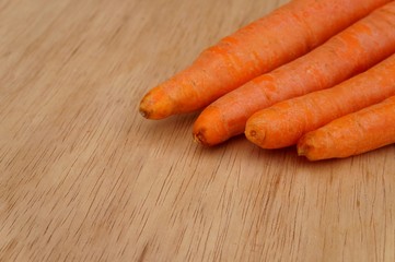 Carrots on wooden background. Organic food concept.