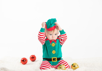 baby disguised elf with hands on the head cap rolled from Christmas balls