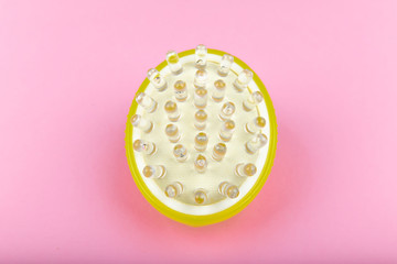 Massage brush on a pink background. Gel brush green. view from above. different angles. Massage brush. Anti-cellulite massage brush. On a pink background. Accessories for massage.