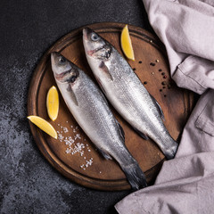 fresh raw whole sea bass. Raw seabass fish with spices and herbs ingredients. Top view with copy space.