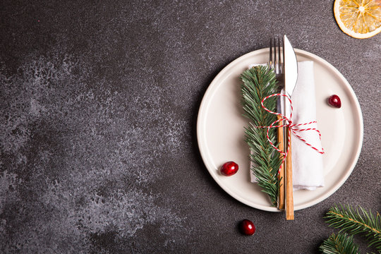 Christmas table with a plate, fork, knife, Christmas tree branches and Christmas decorations. top view, copy space