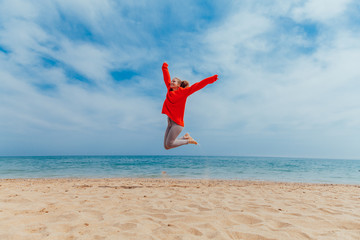girl jumping on a sandy beach sea shore
