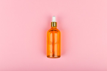 effective can of oil on a pink background. Eco care concept. Skin care products. craft paper. The apartment was lying. Golden oil in a dropper. Pure hemp oil with a bright golden color in a dropper on