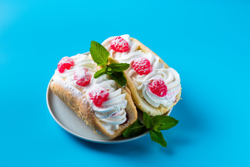 Cake with raspberries and sprinkles on a blue background