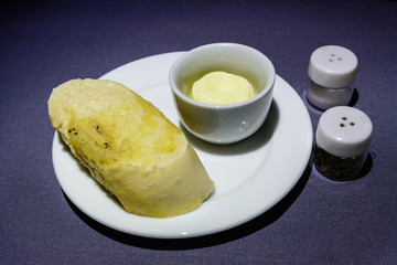 Plate with a slice of bread and a butter bowl