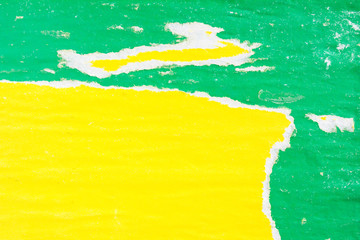 Yellow and green torn and peeling old dirty paper posters with traces of glue texture background.