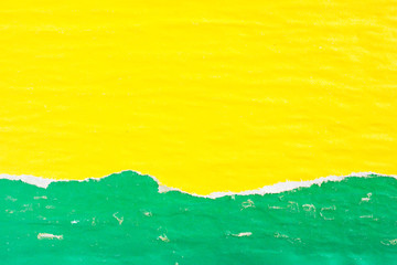 Yellow and green crumpled, ripped and peeling old dirty paper posters with traces of glue texture...