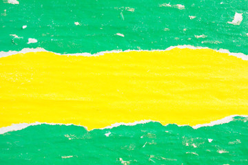 Yellow and green crumpled, ripped and peeling old paper posters and placards with dirty traces of...