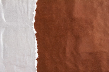 Dark brown and silver grey crumpled, torn and ripped gloss paper posters on rough surface texture...