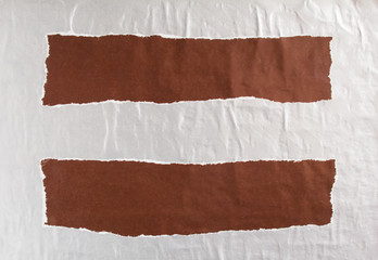 Dark brown and silver gray crumpled, torn and ripped shabby gloss paper poster or placard on a wall...