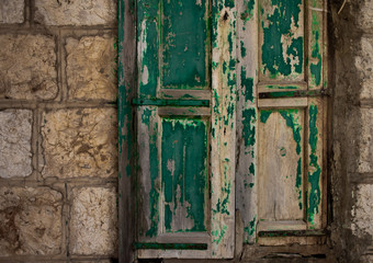 Fototapeta na wymiar old green weathered door on a stone building