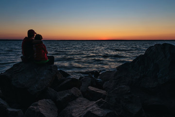 Couple sitting on the stones and hugging each other