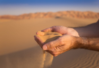 UAE. Hands with sand
