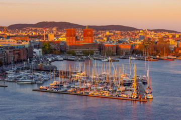 Sunset aeriel view at harbour of Oslo with boats and the famous city hall, Norway - obrazy, fototapety, plakaty