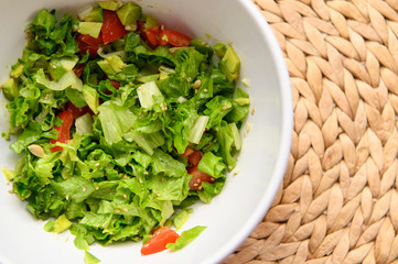 Vegetable salad with avocado, leaves, tomato, sesame seeds, garlic, lemon juice.
