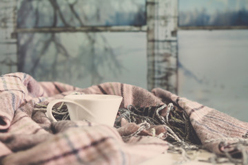 Cozy autumn winter home, Christmas eve. Cup tea, autumn garland on a wooden table near the bed with warm plaids. Autumn lifestyle lagom hygge.holiday and a weekend in the fall in winter on holidays.