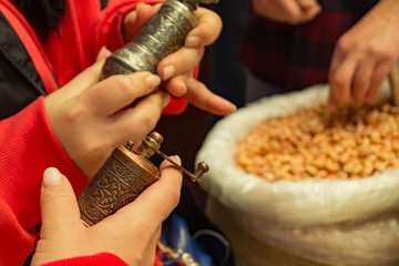 pepper mill in the hands of a woman in the market