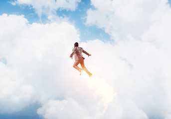 Naklejka premium Businessman in suit and aviator hat flying in sky