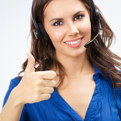 Portrait of happy smiling young support operator or sales phone agent, showing thumbs up gesture