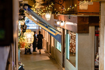 woman is walking on a narrow street in venice