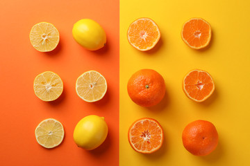 Juicy mandarins and lemons on two tone background, top view