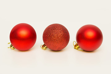 three red Christmas balls on a white background