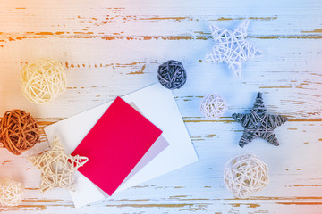  Christmas holiday background: card for text on a white wooden background surrounded by wicker stars and balls. Template for congratulation. Place for text. Top view. Flat lay