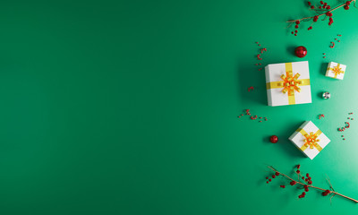Christmas and New Year holiday green background mockup. New Year decoration flat lay. Christmas greeting card. White and gold present boxes and christmas ornaments. Christmas celebration concept.