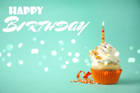 Delicious cupcake with candle on light green background. Happy Birthday