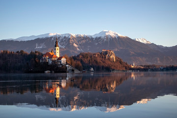Sunrise view of lake Bled in sunny winter with the island, castle and church