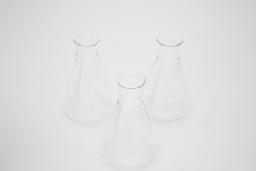 Three scientific laboratory glass erlenmeyer flask isolated on white background