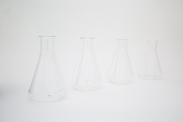 Row of scientific laboratory glass erlenmeyer flask isolated on white background