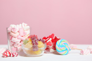 various candy and sweets on the table on a colored background. 