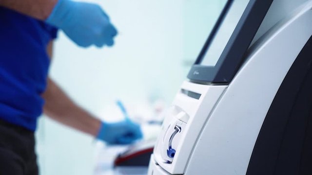 Medical Scientist working in modern lab with blood testing equipment professional medicine research technology genetic biohacking