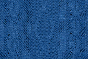 Large woolen background knitted from blue thread. View from above. Element of clothes, style...