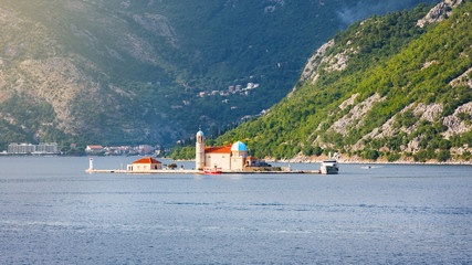 Gospa od Skrpjela, Perast, Montenegro. Small church in Bay of Kotor against mountains in summer Montenegro