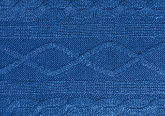 Large woolen background knitted from blue thread. View from above. Element of clothes, style...