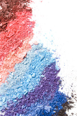 Multicolored crushed eyeshadows with brush isolated on white background.