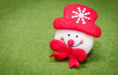 smiling christmas snowman decoration doll on green grass background