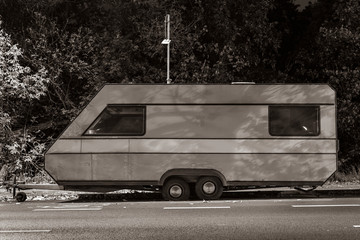 Old dirty caravan at night, old caravan parked on a street, under a street lamp, night photo, black...